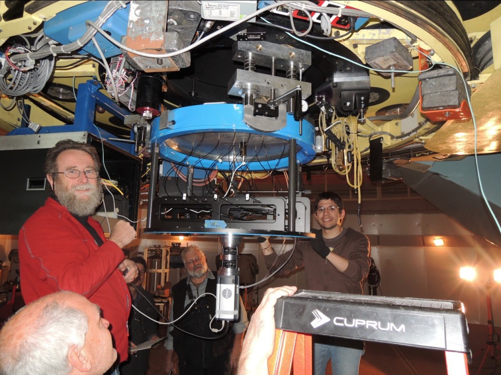 The guiding camera is seen at the bottom of the du Pont Telescope at Las Campanas Observatory in Chile. Fred Hearty (head, bottom left), Paul Harding (left, red jacket), John Wilson (behind Paul), French Leger (behind the guiding camera), Juan Trujillo (to right of guiding camera), and John Parejko (who took the picture) are responsible for the recent progress.
