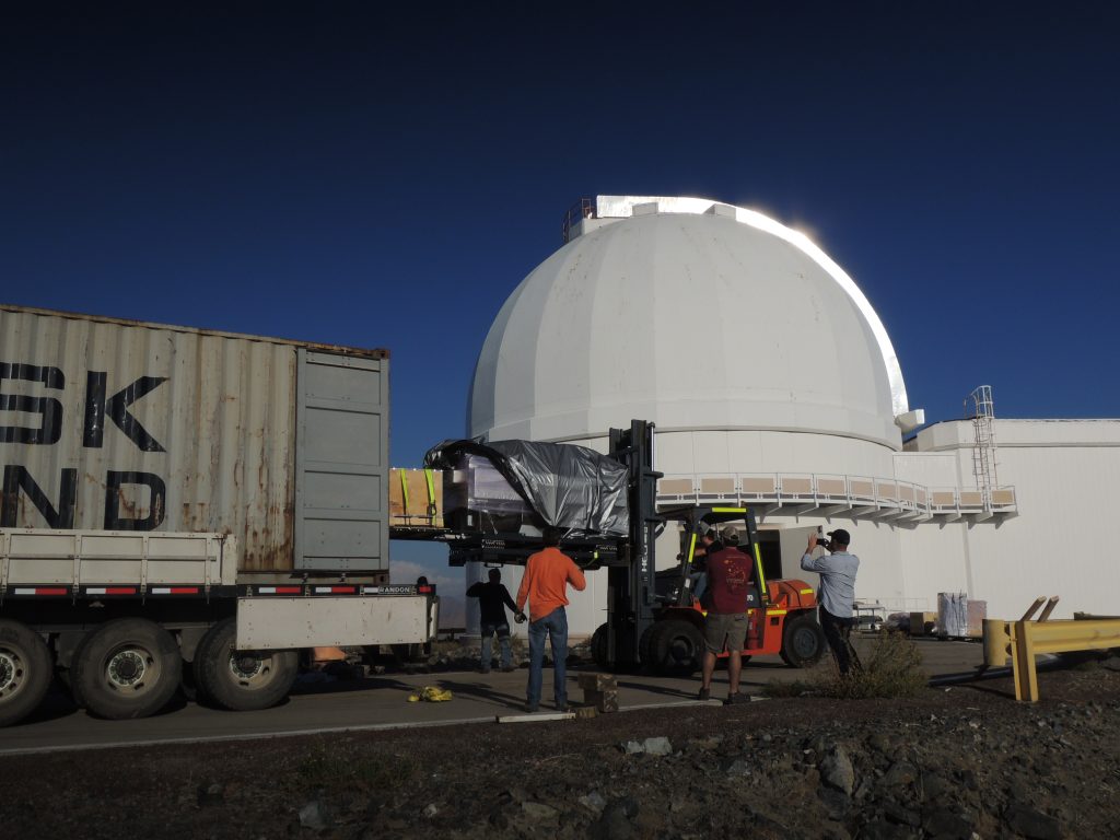 1.APOGEE-Sur está siendo retirado del contenedor delante del telescopio du Pont del Observatorio de Las Campanas. APOGEE-South is being removed from its shipping container at the du Pont telescope, Las Campanas Observatory.